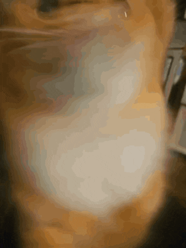 a blurred image of a cat 's face with a few spots of white on it