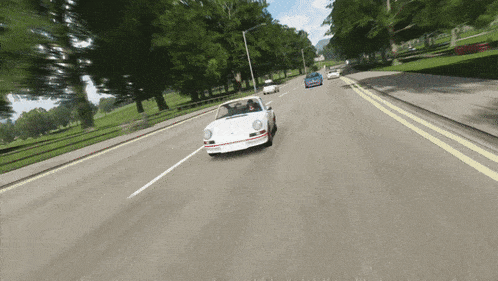 a white car is driving down a road with other cars