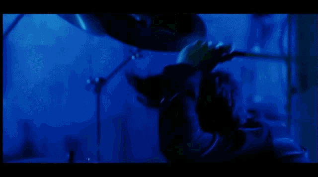a man is playing a guitar in a dark room