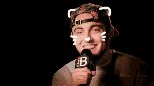 a man wearing a hat and holding a microphone with a b on it .
