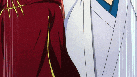 a man in a white robe and a woman in a red cape are standing next to each other