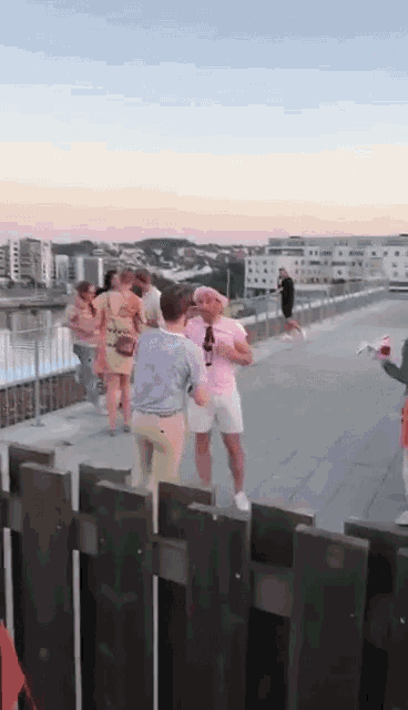a group of people are standing on top of a rooftop