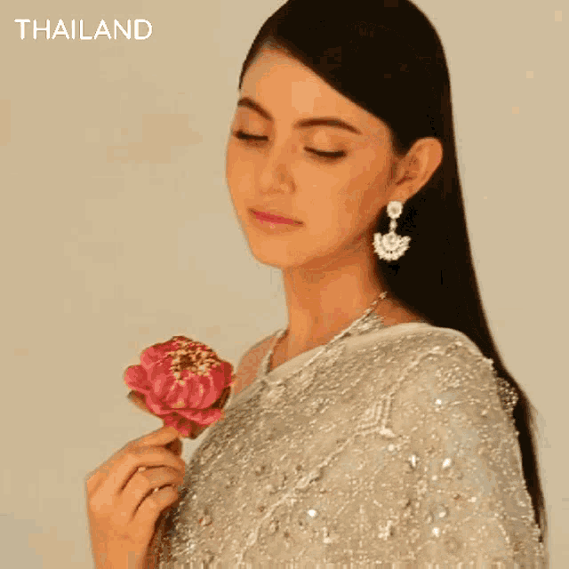a woman is wearing earrings and a necklace and the word thailand is on the bottom