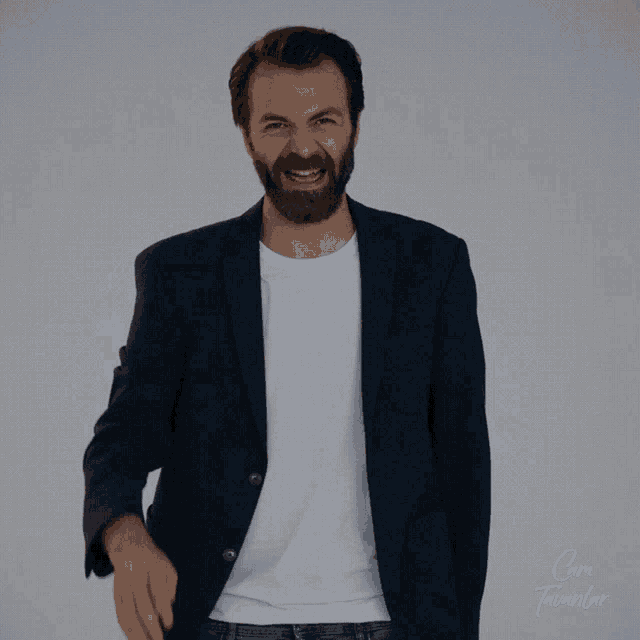 a man with a beard wearing a blue jacket and white shirt