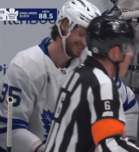 a hockey player wearing a number 35 jersey talks to a referee