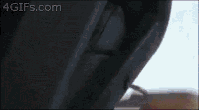 a close up of a person 's hand holding a metal hook on a black object .