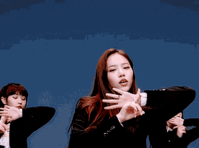 a woman in a suit and tie holds her hand to her face
