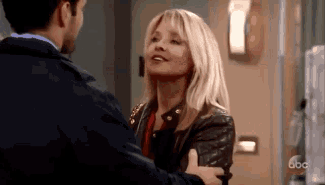a man and a woman are hugging each other in a hallway .