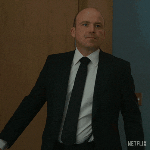 a man in a suit and tie is saying " not sure i give a fuck "