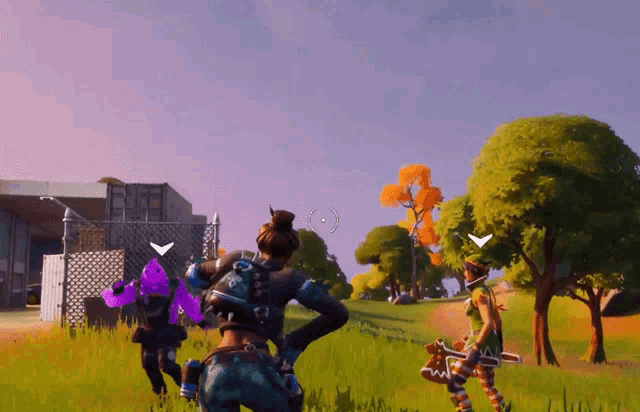 a group of people are playing a video game in a field with trees and a building in the background