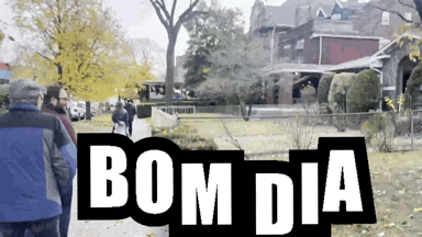 a group of people walking down a sidewalk with bom dia written on the top