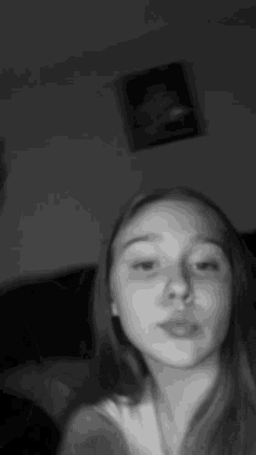 a woman is taking a selfie in a black and white photo .