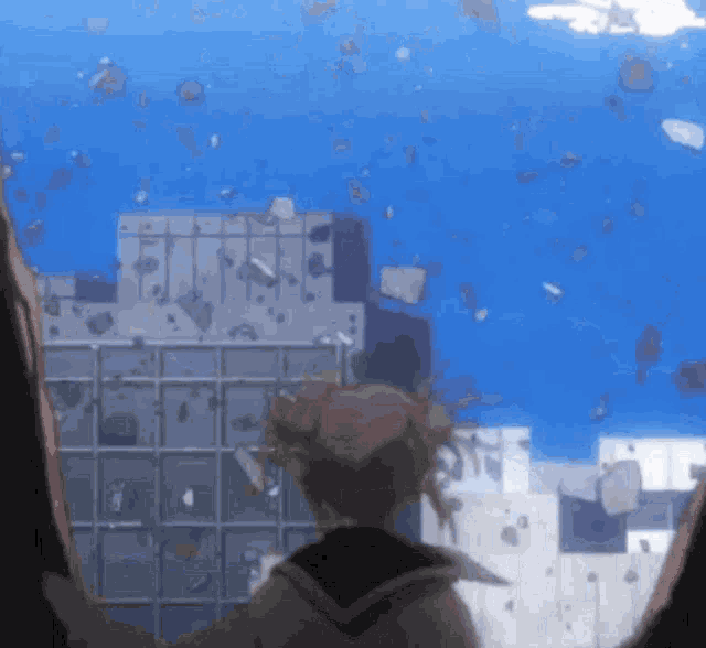 a girl is standing in front of a destroyed building in the water
