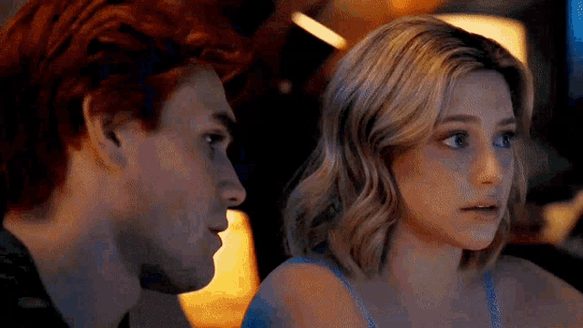 a man and a woman are looking at each other in a restaurant .