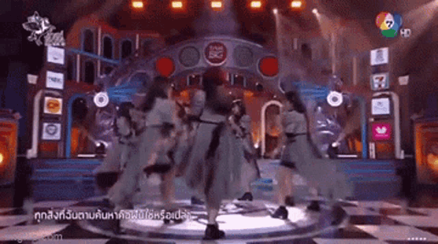 a group of women are dancing on a stage in front of a sign that says the 5g .