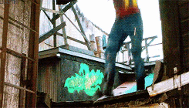 a man is standing on a ledge with graffiti on it