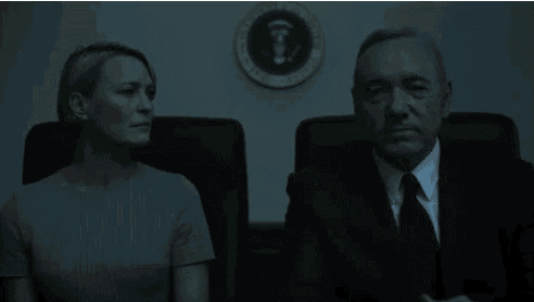 a man and a woman are sitting next to each other in front of a white house seal .