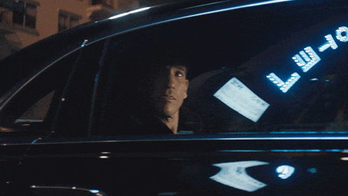a man is looking out of a car window with a sign that says trust