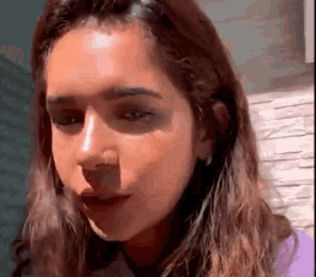 a close up of a woman 's face with long hair looking at the camera .