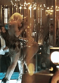 a woman is dancing on a pole in front of a mirror