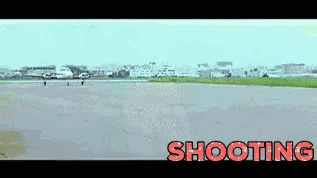 a plane is taking off from a runway with the word shooting in red