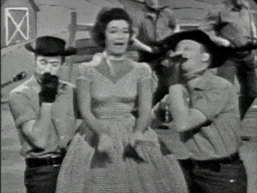 a black and white photo of a group of men and a woman