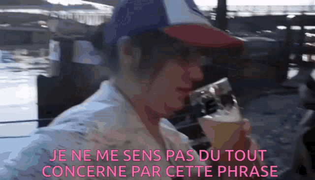 a woman in a hat drinks from a glass with the words je ne me sens pas du tout concernne par cette phrase