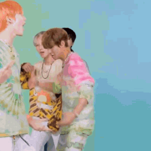 a group of young men are standing next to each other on a blue background and dancing .