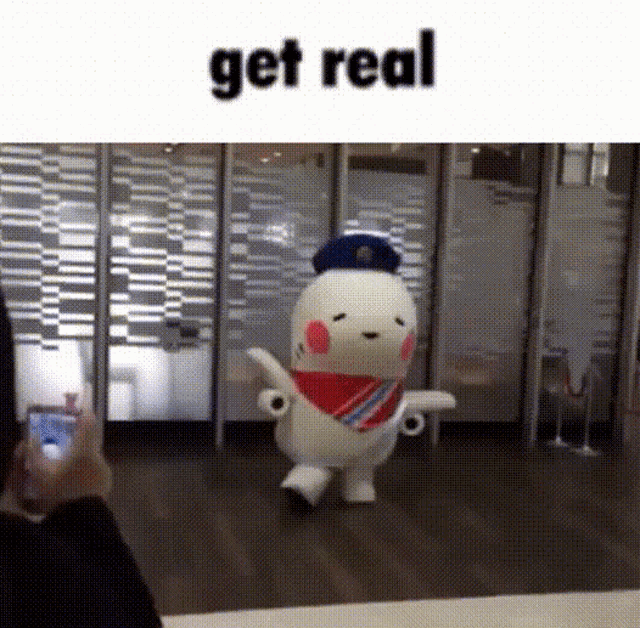 a person is taking a picture of a stuffed animal that says get real on the bottom