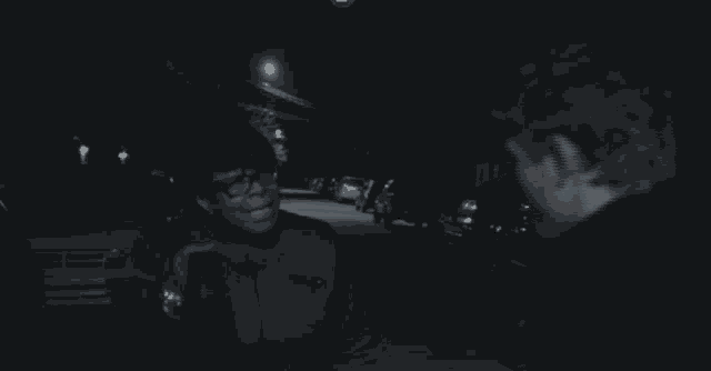 a man and a woman are standing on a street at night