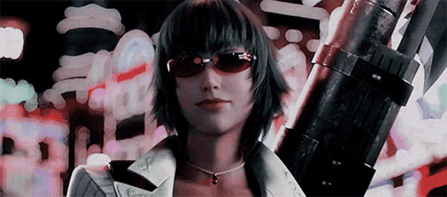 a woman wearing sunglasses is holding a large object in her hand