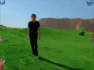 a man in a black shirt walks through a grassy field