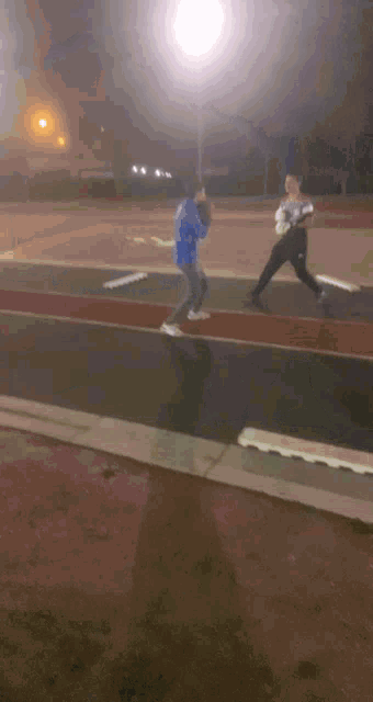 a man in a blue jacket is throwing a ball to another man