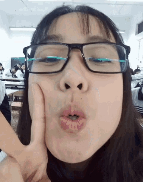 a girl wearing glasses makes a funny face