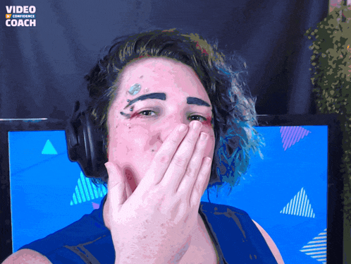 a woman wearing headphones is covering her mouth in front of a screen that says video content coach