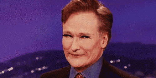 a man in a suit and tie is smiling on a stage .