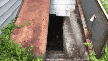 a rusty metal staircase leading up to a concrete staircase