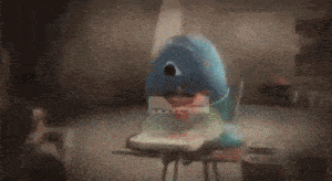 a cartoon character is sitting at a desk in a dark room with a laptop .