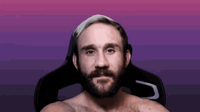 a man with a beard is sitting in a black chair