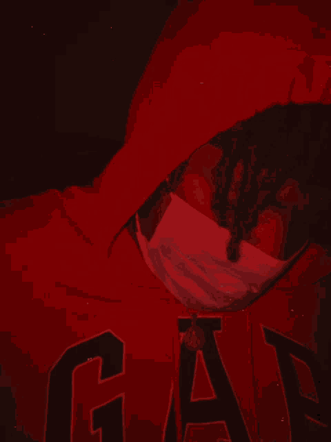 a person wearing a red gap hoodie with a mask on