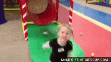 a girl in a black shirt is playing in a playground with the words make gifs at gifsoup.com at the bottom