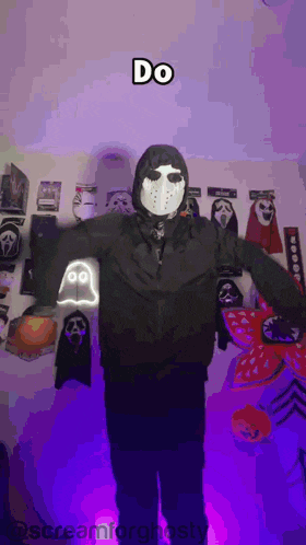 a person in a jason voorhees costume is standing in front of a wall with scream masks
