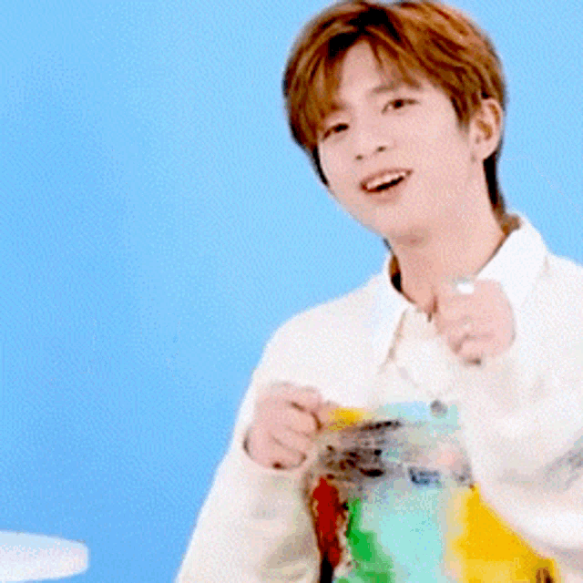 a man in a white shirt is pointing his fist at the camera with chinese writing behind him