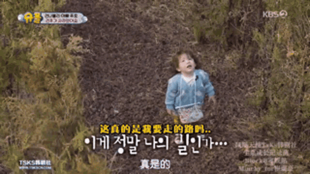 a baby in a blue sweater with chinese writing