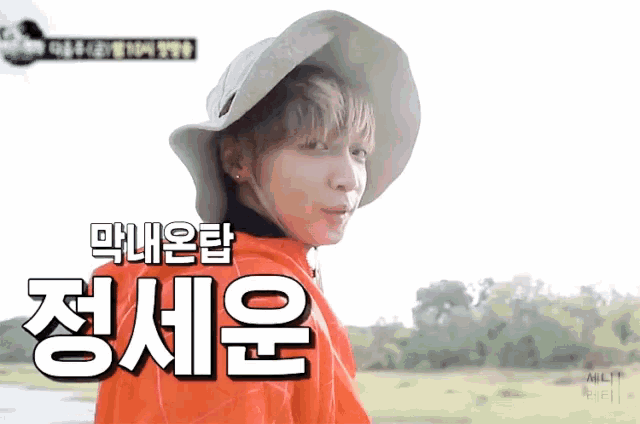 a person wearing a hat and a red jacket with korean writing on it .