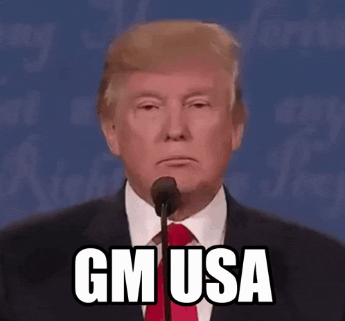 donald trump is giving a speech in front of a microphone and says gm usa .