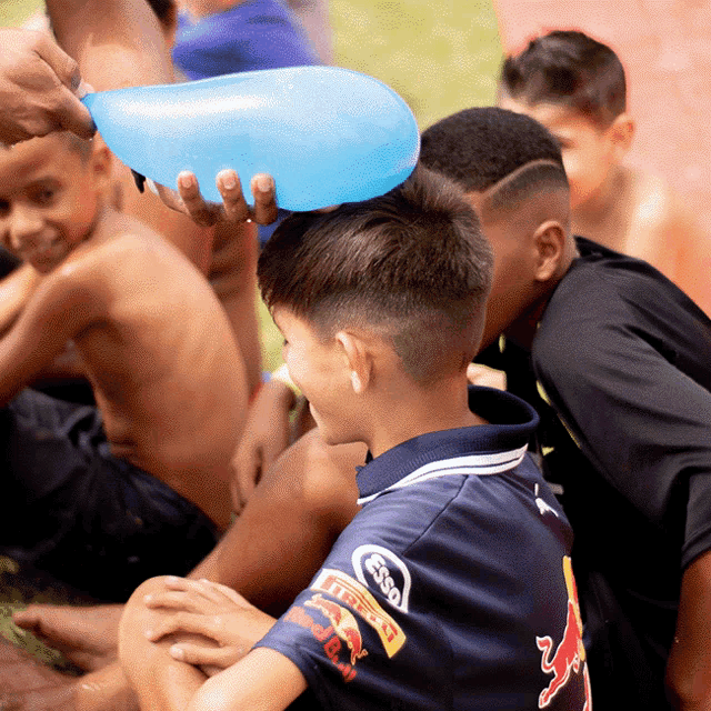 a boy wearing a blue shirt with red bull on the sleeves
