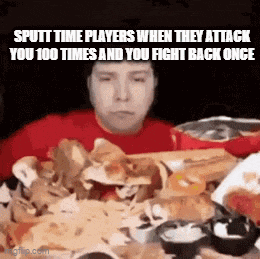 a man in a red shirt is sitting at a table with a bunch of food and chips .