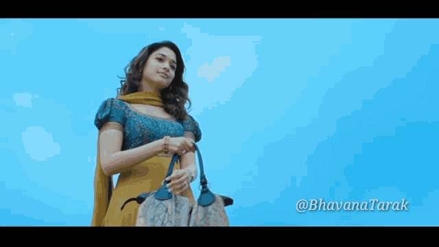 a woman in a yellow dress is holding a purse