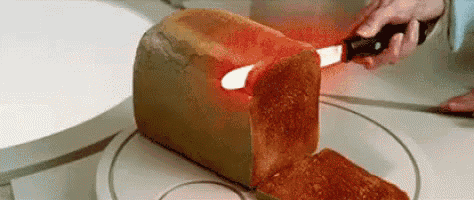 a loaf of bread is being cut with a knife on a plate on a table .